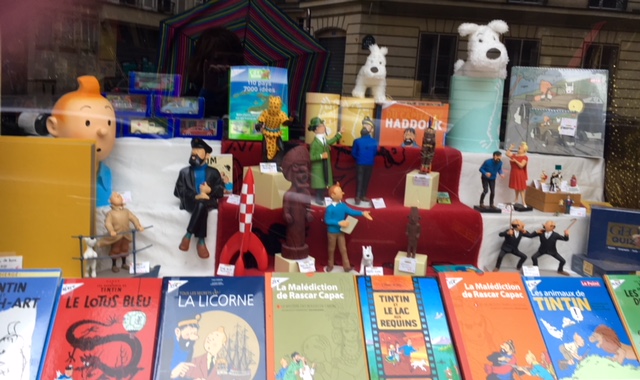 Tin Tin books and figurines brighten a shop window.